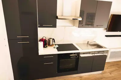 a kitchen with black and white cabinets and a sink at T2 Cozy Cannes 4 people Near Suquet in Cannes