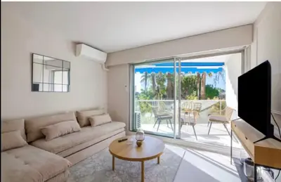 a living room with a couch and a tv at Appartement proche du centre de Cannes avec parking in Cannes