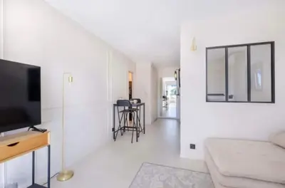 a white living room with a tv and a couch at Appartement proche du centre de Cannes avec parking in Cannes