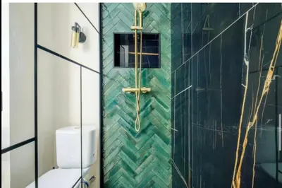 a bathroom with a green tiled shower with a toilet at Appartement proche du centre de Cannes avec parking in Cannes