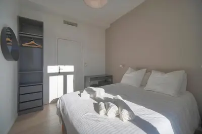 a bedroom with a bed with two pairs of slippers at DUPLEX 3 Chambres TERRASSE et 1 DEPENDANCE A4B026 in Cannes