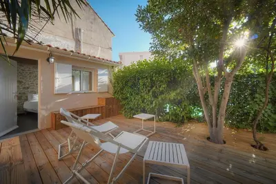 a deck with chairs and a table and a tree at DUPLEX 3 Chambres TERRASSE et 1 DEPENDANCE A4B026 in Cannes