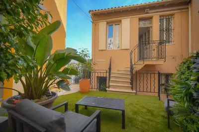 a yard with a couch and a table in front of a house at DUPLEX 3 Chambres TERRASSE et 1 DEPENDANCE A4B026 in Cannes