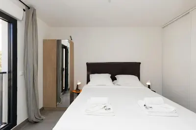 a bedroom with a large white bed and a window at L'AZUERA Cannes center 2P Design 4 Pers Secure Parking in Cannes