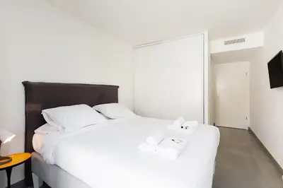 a bedroom with a white bed with two towels on it at L'AZUERA Cannes center 2P Design 4 Pers Secure Parking in Cannes