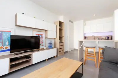 a living room with a tv and a kitchen at L'AZUERA Cannes center 2P Design 4 Pers Secure Parking in Cannes