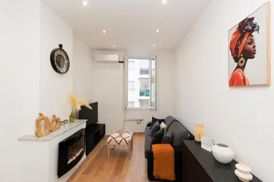 a living room with a black couch and a fireplace at Immogroom - 1Bedroom - CityCenter - AC in Cannes