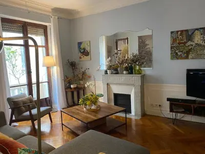 a living room with a table and a fireplace at Trois pièces Gallieni in Cannes