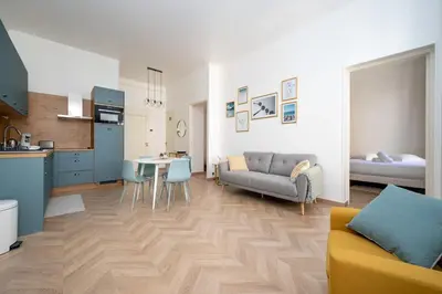 a kitchen and living room with a couch and a table at Spacious and Bright Near Train Station and Palais des Festivals - BENAKEY in Cannes