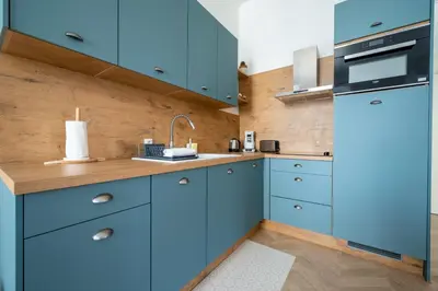 a kitchen with blue cabinets and a sink at Spacious and Bright Near Train Station and Palais des Festivals - BENAKEY in Cannes