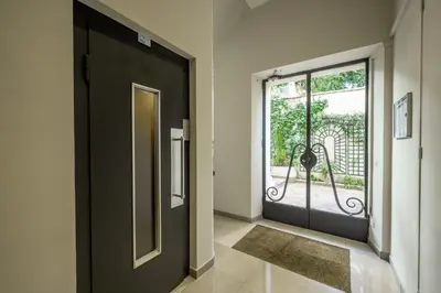 a hallway with a black door and a window at Spacious and Bright Near Train Station and Palais des Festivals - BENAKEY in Cannes