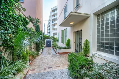 a walkway between two buildings with a blue door at Spacious and Bright Near Train Station and Palais des Festivals - BENAKEY in Cannes