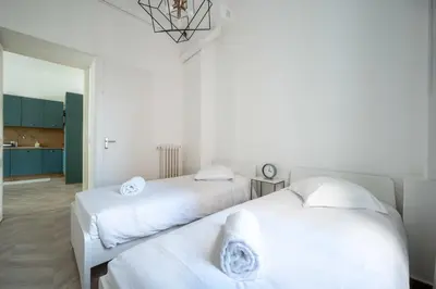 two white beds in a room with a kitchen at Spacious and Bright Near Train Station and Palais des Festivals - BENAKEY in Cannes