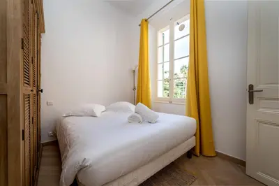 a white bed in a room with a window at Spacious and Bright Near Train Station and Palais des Festivals - BENAKEY in Cannes