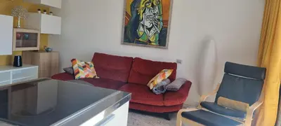 a living room with a red couch and a chair at Magnifique deux pièces Lacour in Cannes