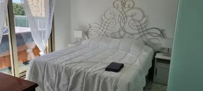 a large white bed with a black box on it at Magnifique deux pièces Lacour in Cannes