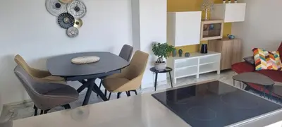 a kitchen and living room with a table and chairs at Magnifique deux pièces Lacour in Cannes