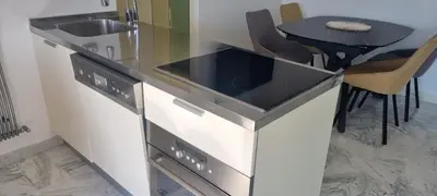 a kitchen with a stove and a sink and a table at Magnifique deux pièces Lacour in Cannes