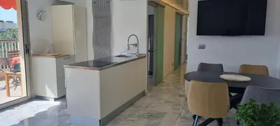 a kitchen with a sink and a table with chairs at Magnifique deux pièces Lacour in Cannes