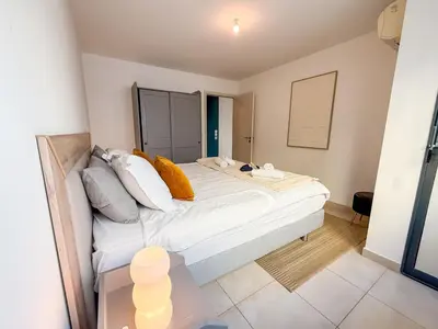a bedroom with a large bed and a night stand at Charming Terrace Apartment with Garden Views - Cannes City Center in Cannes