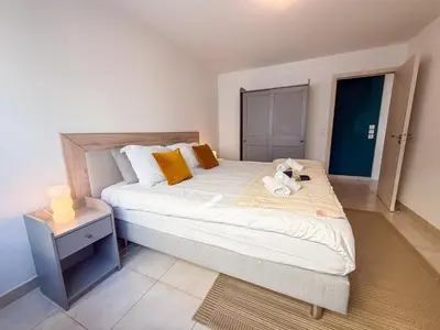 a bedroom with a large bed and a mirror at Charming Terrace Apartment with Garden Views - Cannes City Center in Cannes