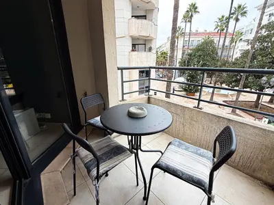 a kitchen and living room with a table and a couch at Charming Terrace Apartment with Garden Views - Cannes City Center in Cannes