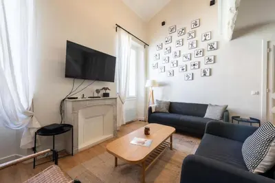 a kitchen with a bar with stools and a staircase at Résidence Rare ! Duplex De Style En Plein Centre Ville - RARE ! Duplex de style en plein centre ville MAE-5823 in Cannes