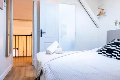 a white bedroom with two beds and a skylight at Résidence Rare ! Duplex De Style En Plein Centre Ville - RARE ! Duplex de style en plein centre ville MAE-5823 in Cannes
