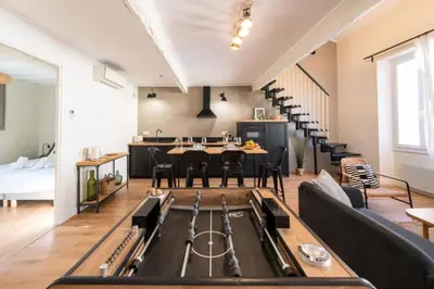 a kitchen with black cabinets and a bar with stools at Résidence Rare ! Duplex De Style En Plein Centre Ville - RARE ! Duplex de style en plein centre ville MAE-5823 in Cannes