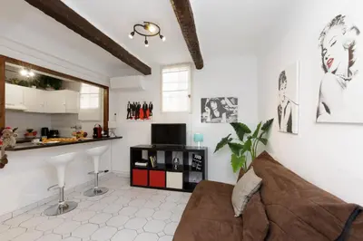 a living room with a couch and a kitchen at Volupte YourHostHelper in Cannes