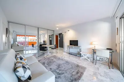 a living room with a white couch and a table at 2 pièces à deux pas du centre ville de Cannes in Cannes