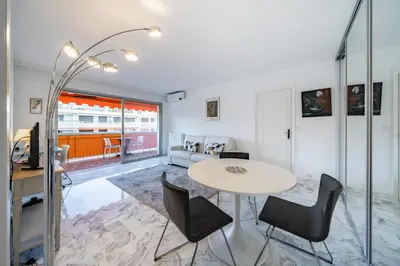 a living room with a table and chairs at 2 pièces à deux pas du centre ville de Cannes in Cannes