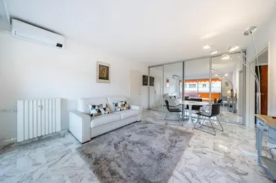 a living room with a white couch and a table at 2 pièces à deux pas du centre ville de Cannes in Cannes