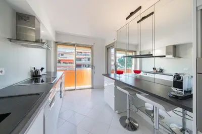 a large white kitchen with a large counter top at 2 pièces à deux pas du centre ville de Cannes in Cannes