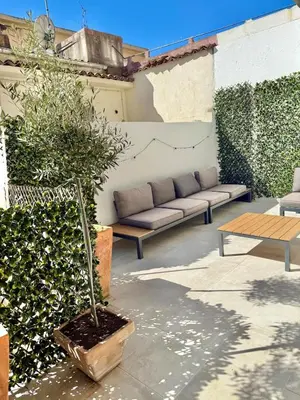 a patio with a couch and a potted plant at 2 bedrooms, large terrace, city center in Cannes
