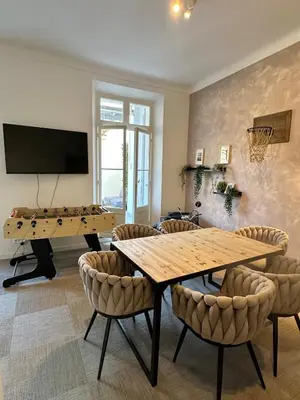 a living room with a ping pong table and chairs at 2 bedrooms, large terrace, city center in Cannes