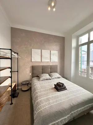 a bedroom with a large bed and a ladder at 2 bedrooms, large terrace, city center in Cannes