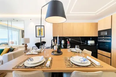 a dining room table with chairs and a black light fixture at Résidence 3p Terrasse Vue Mer – Résidence De Standing - 3P Terrasse Vue Mer – Résidence de Standing MAE-3293 in Cannes