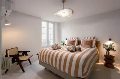 a bedroom with a large bed with a striped blanket at Maya Cannes in Cannes
