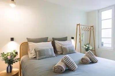 a bed with pillows on it in a bedroom at Maya Cannes in Cannes