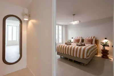 a bedroom with a bed and a large mirror at Maya Cannes in Cannes