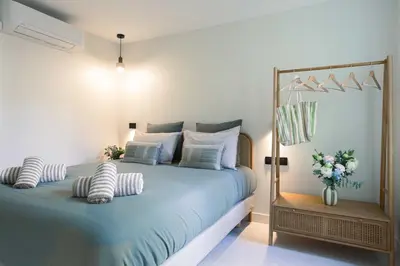 a bedroom with a bed with blue sheets and pillows at Maya Cannes in Cannes