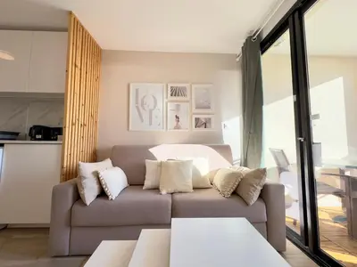 a living room with a couch with pillows at Les Ingres 2 - SCLS Rentals in Cannes