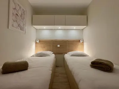 two twin beds in a room with a window at Les Ingres 2 - SCLS Rentals in Cannes