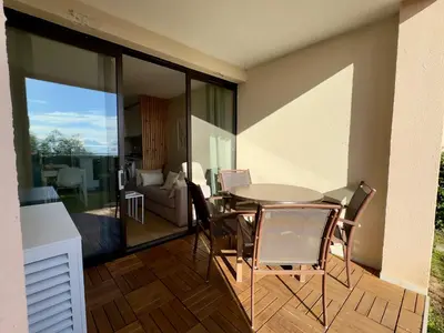 a dining room with a table and chairs on a patio at Les Ingres 2 - SCLS Rentals in Cannes