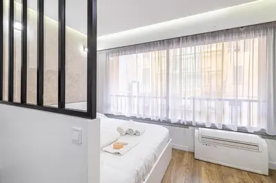 a bedroom with a bed and a window at 8 MERLE T2 - Appartement moderner pour 4 personnes proche Palais in Cannes