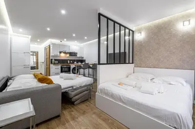 two beds in a small room with a kitchen at 8 MERLE T2 - Appartement moderner pour 4 personnes proche Palais in Cannes
