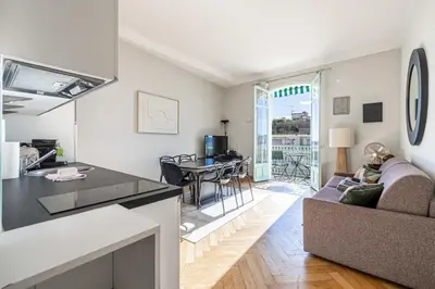 a kitchen and living room with a couch and a table at 20 LACROIX - Cozy 2-bedroom apartment with balcony and sea view in Cannes