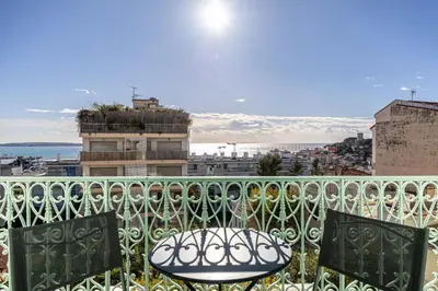 a balcony with a table and chairs on a building at 20 LACROIX - Cozy 2-bedroom apartment with balcony and sea view in Cannes