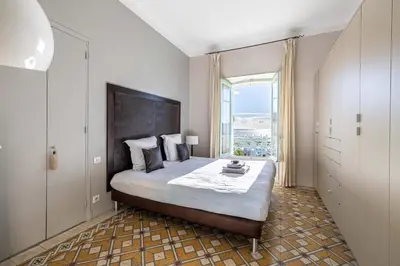 a bedroom with a large bed with a large window at 20 LACROIX - Cozy 2-bedroom apartment with balcony and sea view in Cannes